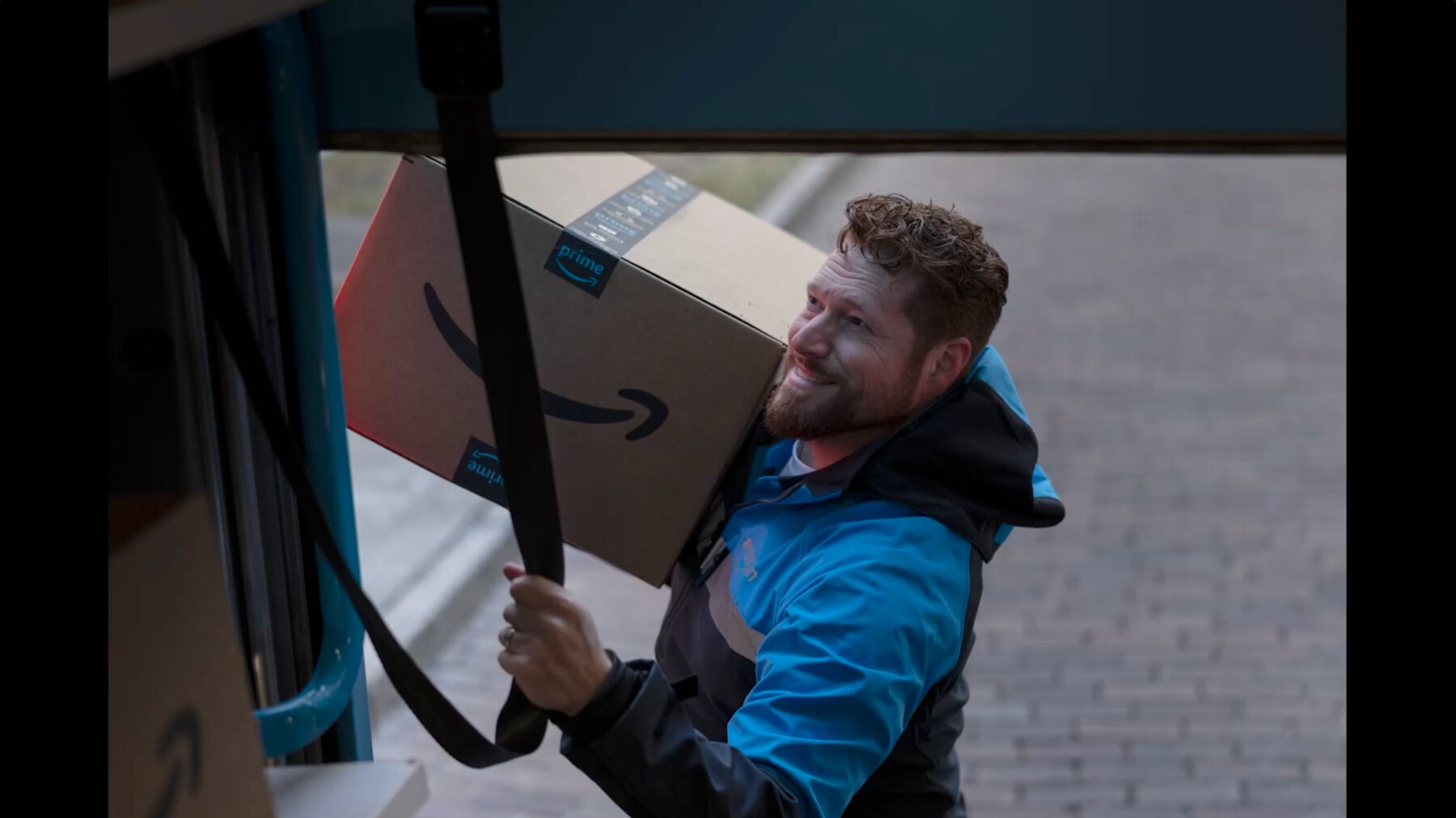 Amazon delivery driver carrying packages out of a delivery van