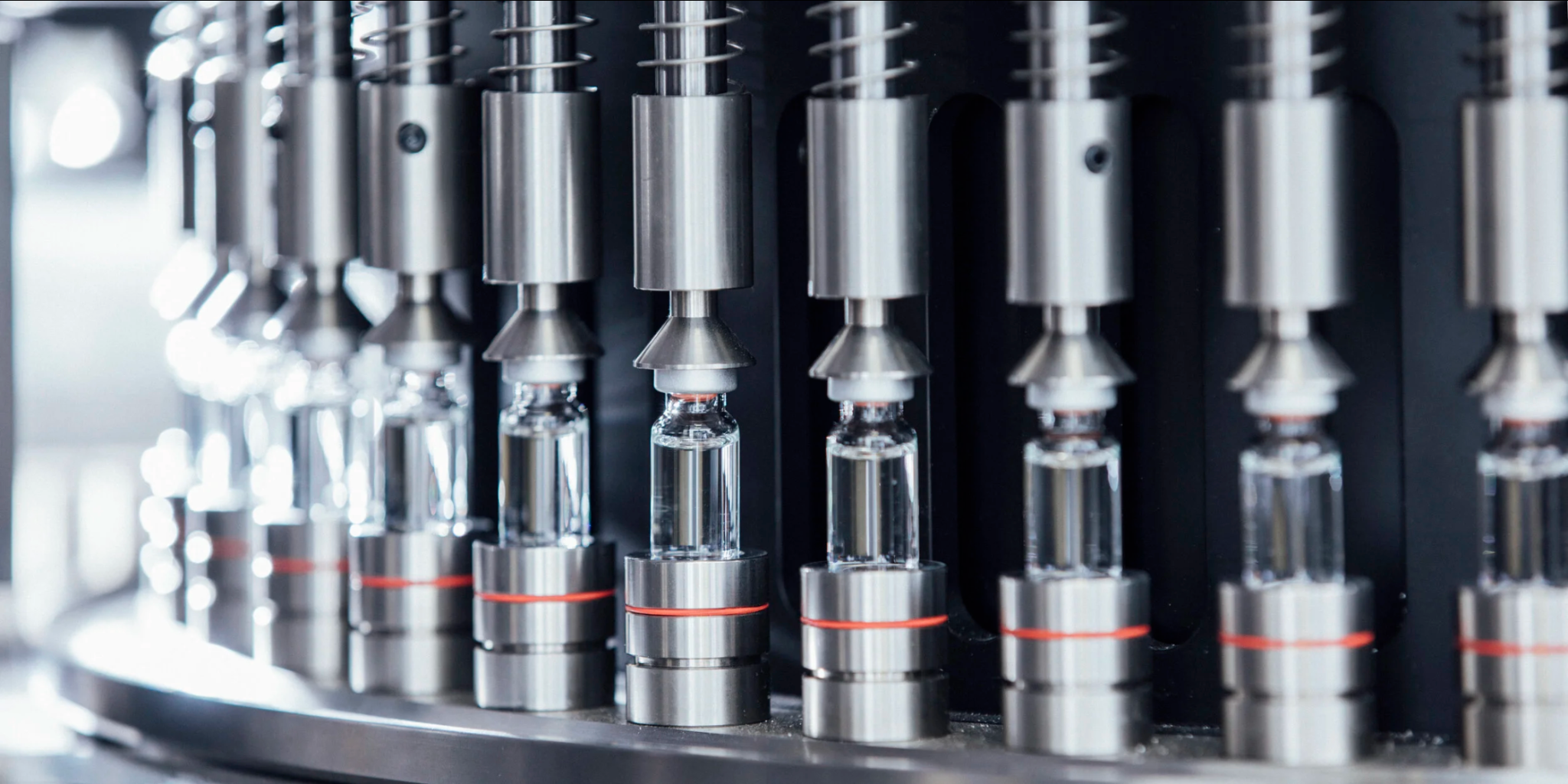 Glass vials moving through a precision filling line