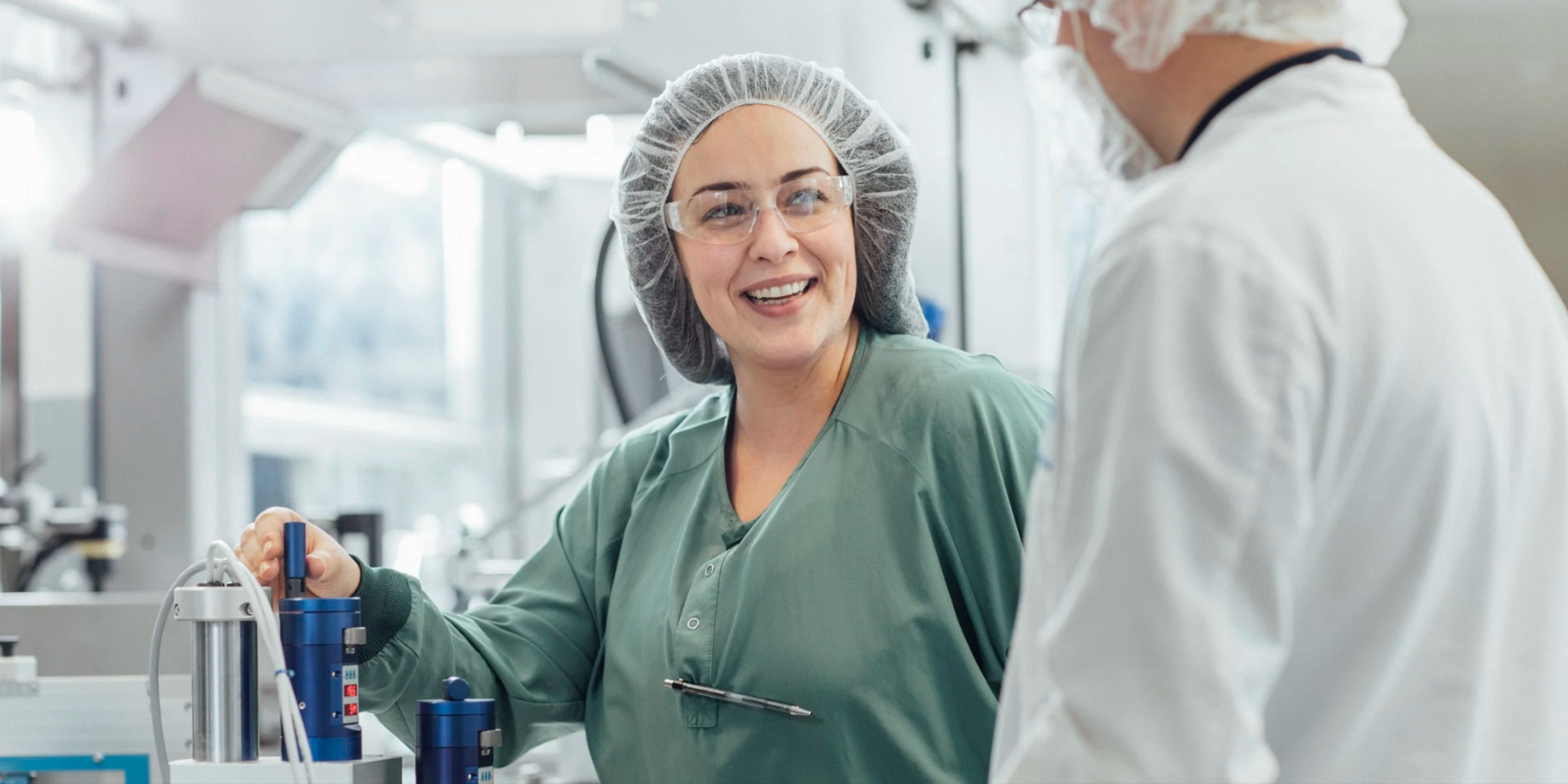 Scientist smiling while working with a colleague in a bright laboratory
