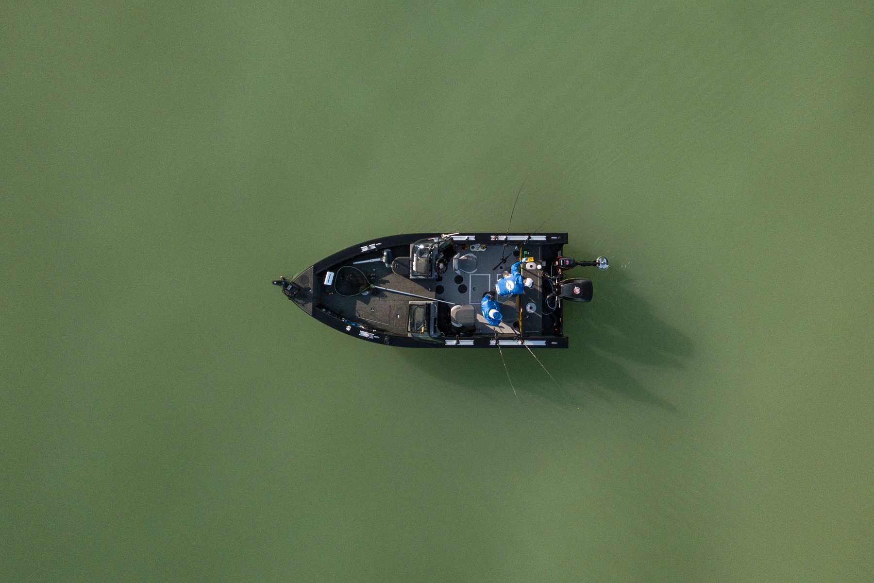 Fishing boat viewed from directly above on green water