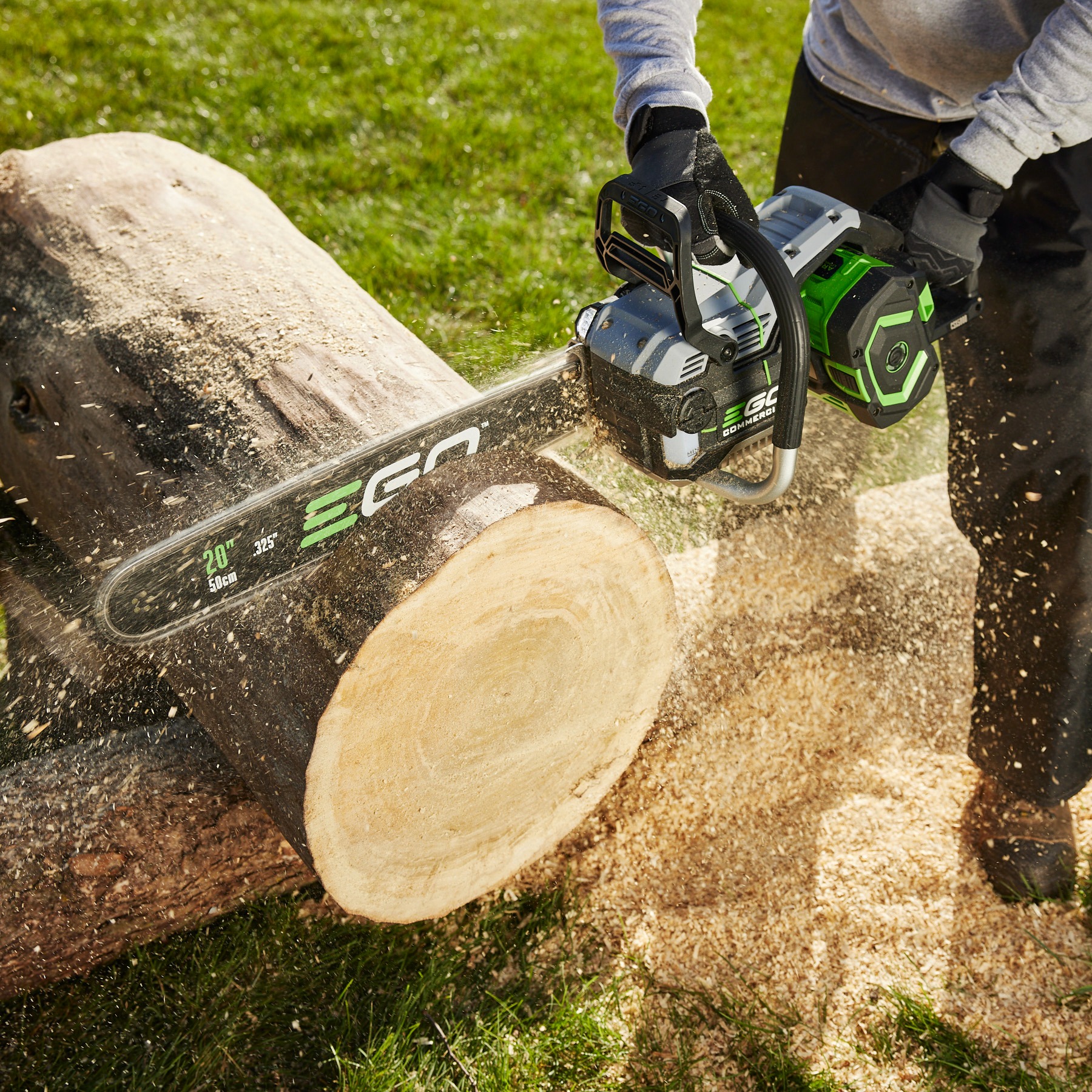 Battery-powered chainsaw cutting through a log