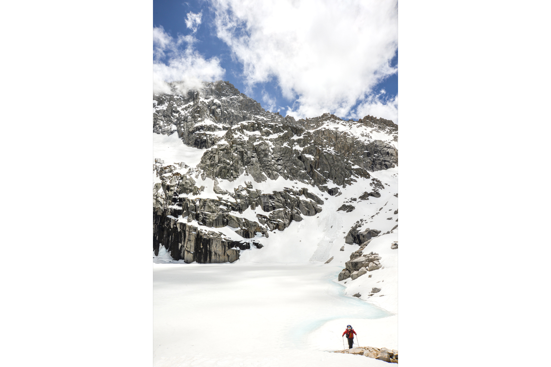 Small figure crossing a snowy mountain landscape